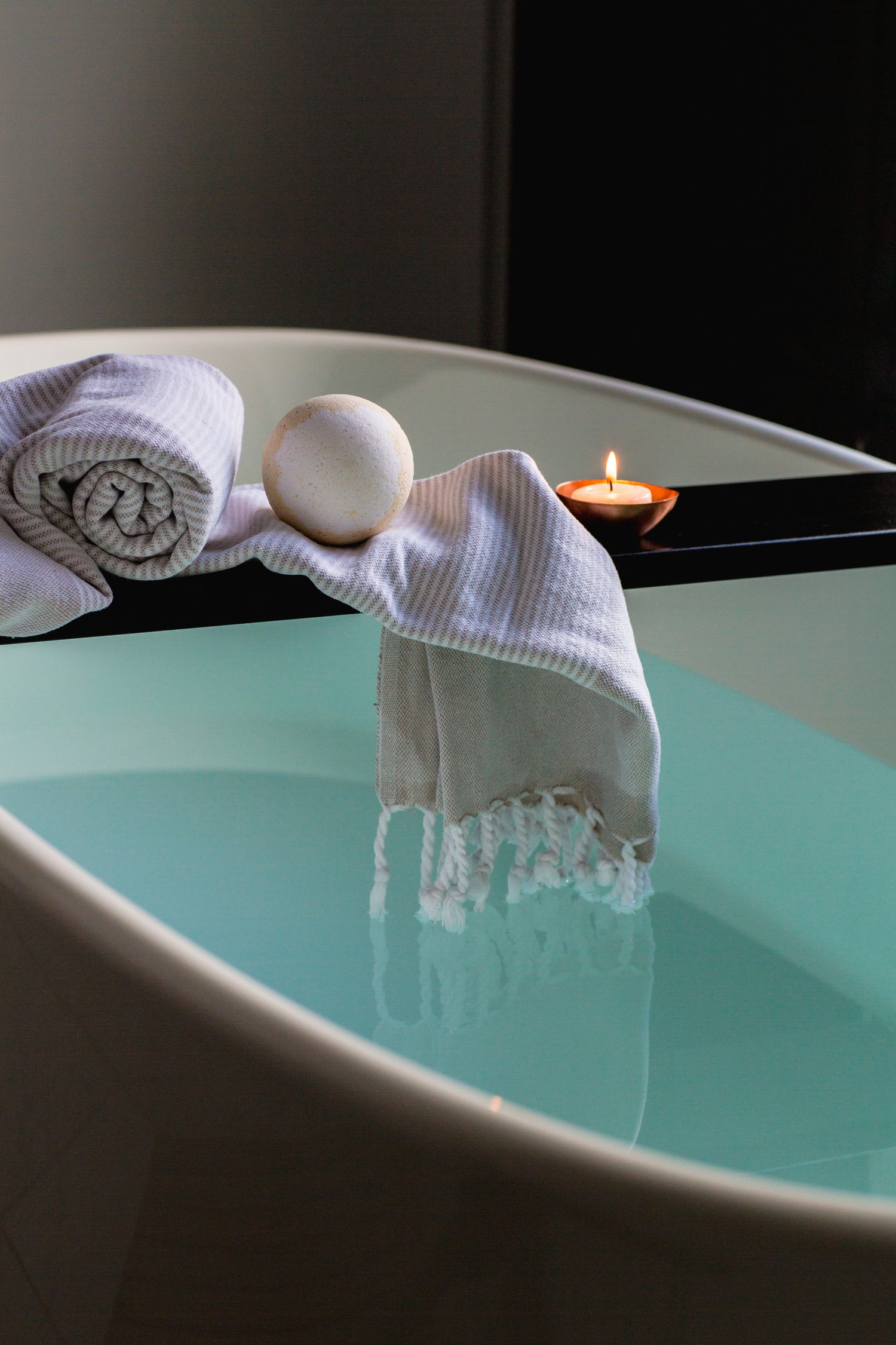 a relaxing bath tub with a candle and towels