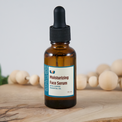 Brown glass bottle of moisturizing face serum on a wooden surface with neutral background